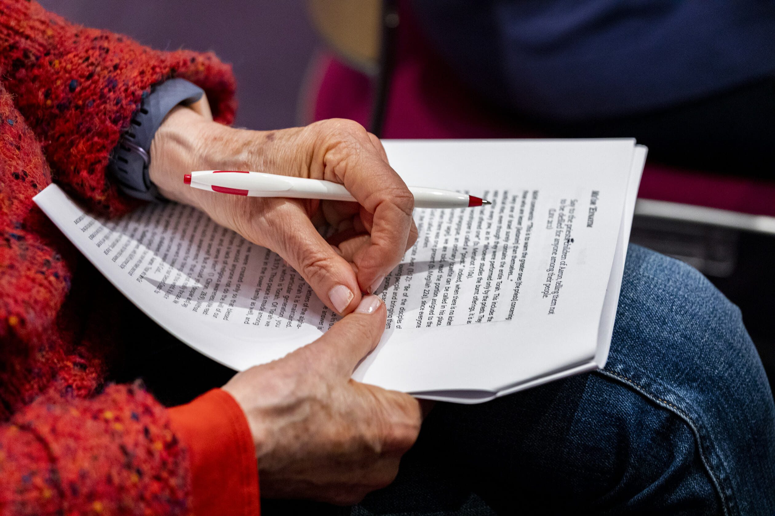 woman holding paper with pen in hand