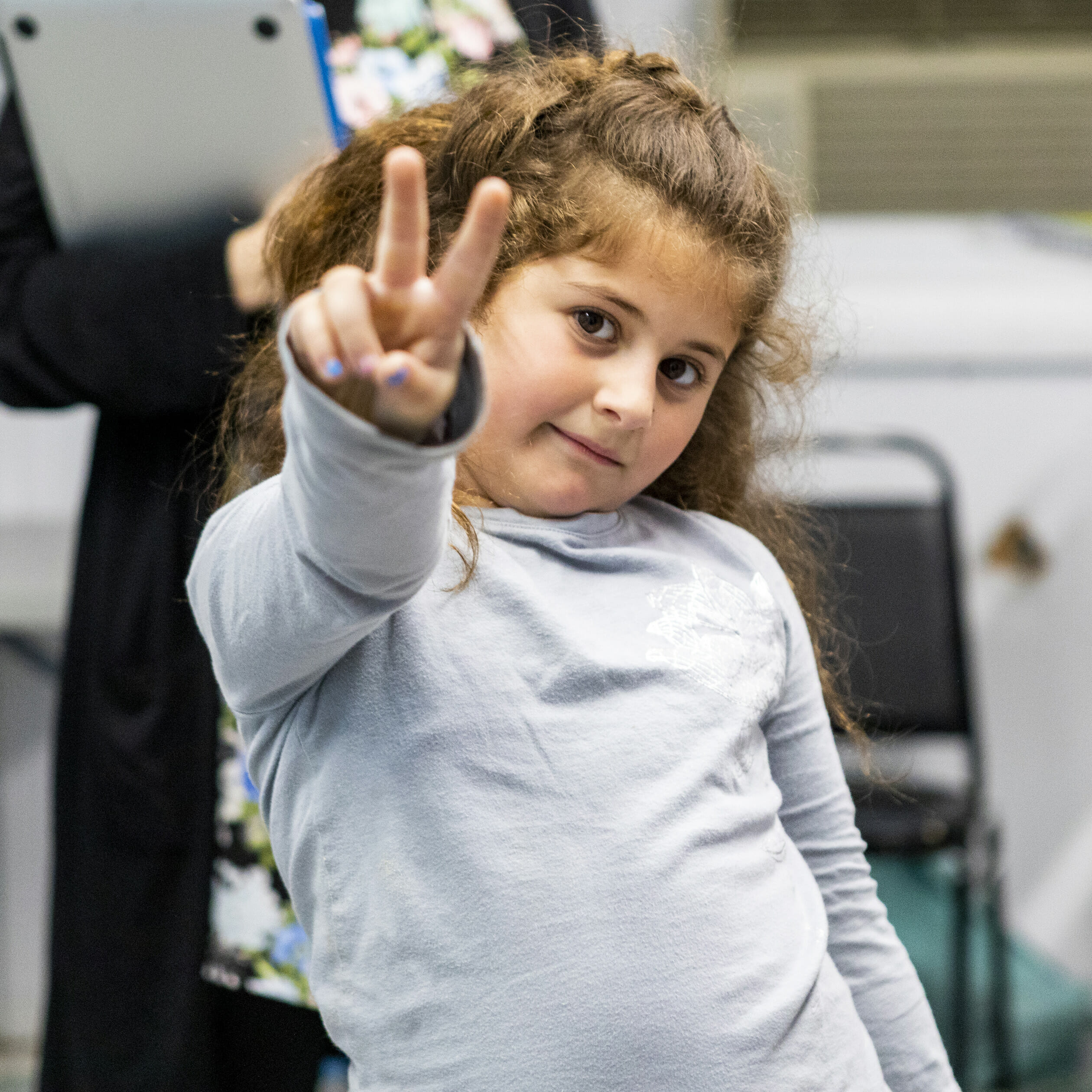 little girl giving peace sign