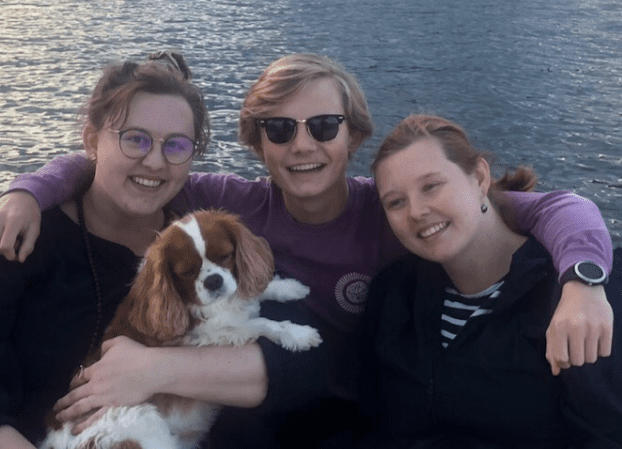 family with a dog on a lake